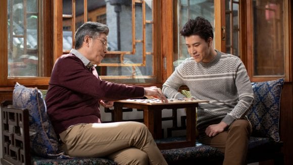 Asian father son playing a board game