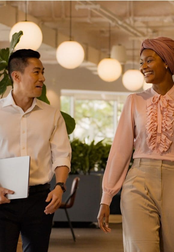 A person holding laptop is talking to a lady